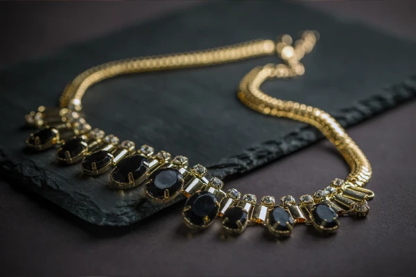 Elegant Gold Necklace with Black Gems on Display